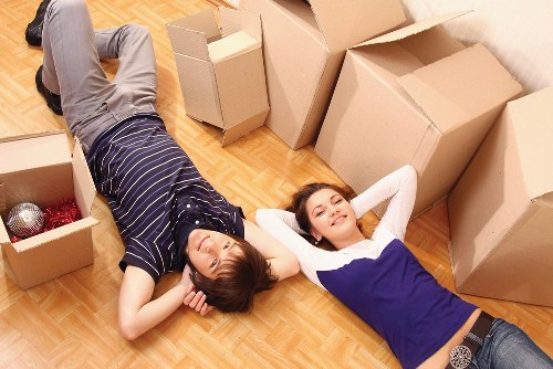 Movers carrying furniture down stairs in a Nunhead flat